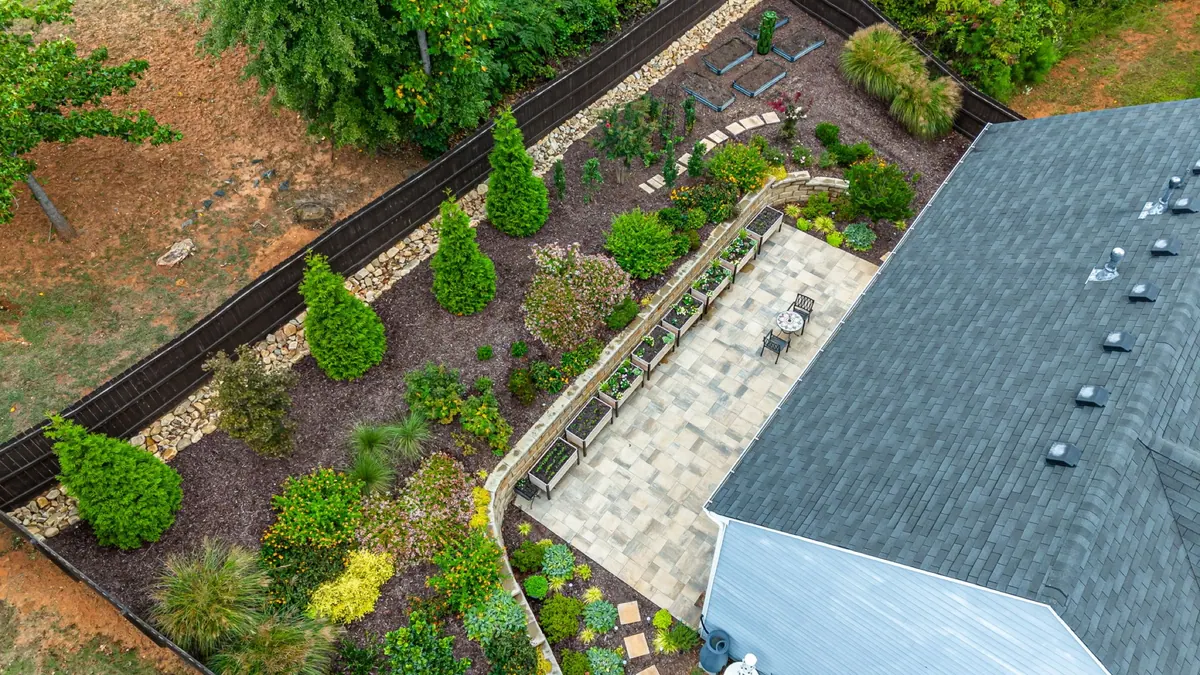 Aerial view of a GreenTree full-yard design: patio, walls, and planting beds from above