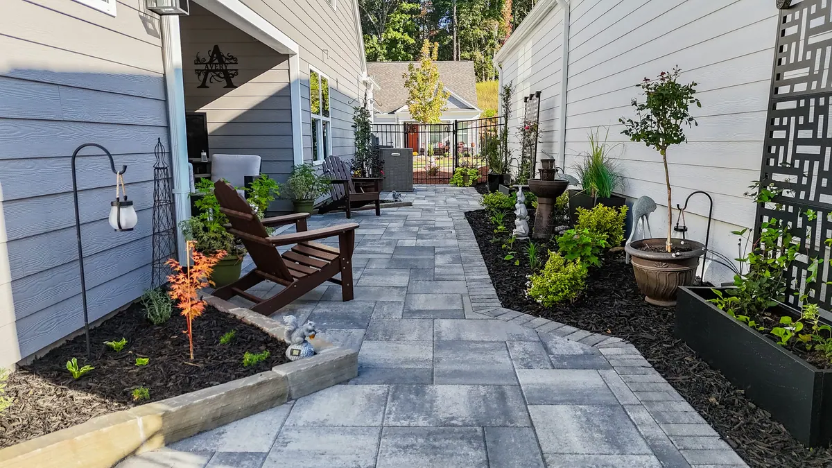 The full paver side-passage with seating, planters, and privacy screens at the Avery project