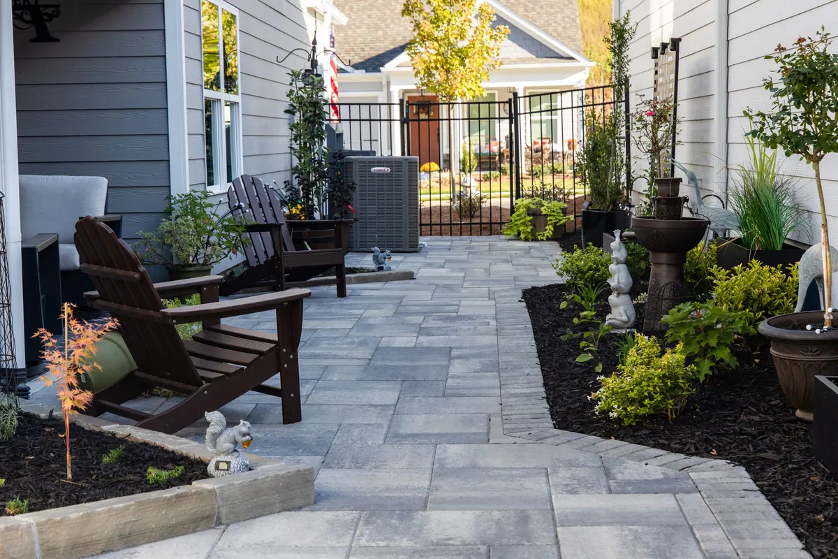 Paver patio with Adirondack seating, fountain, and planting beds at the Avery project