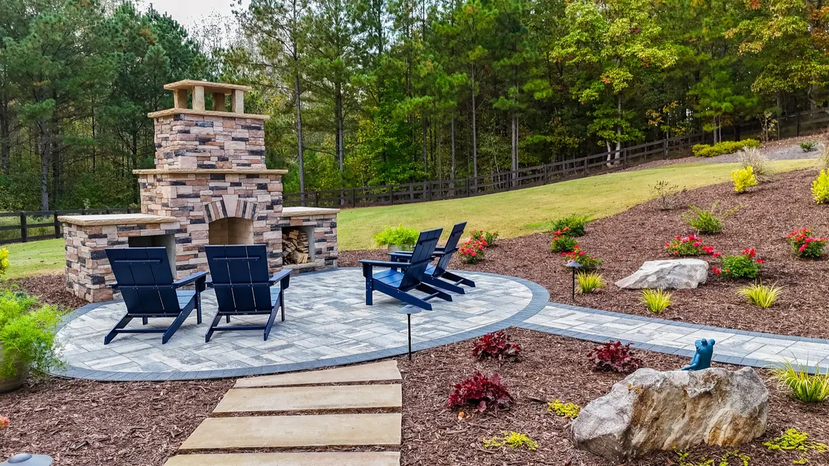 Stone fireplace and Adirondack chairs on a circular paver patio, the Ball Ground project