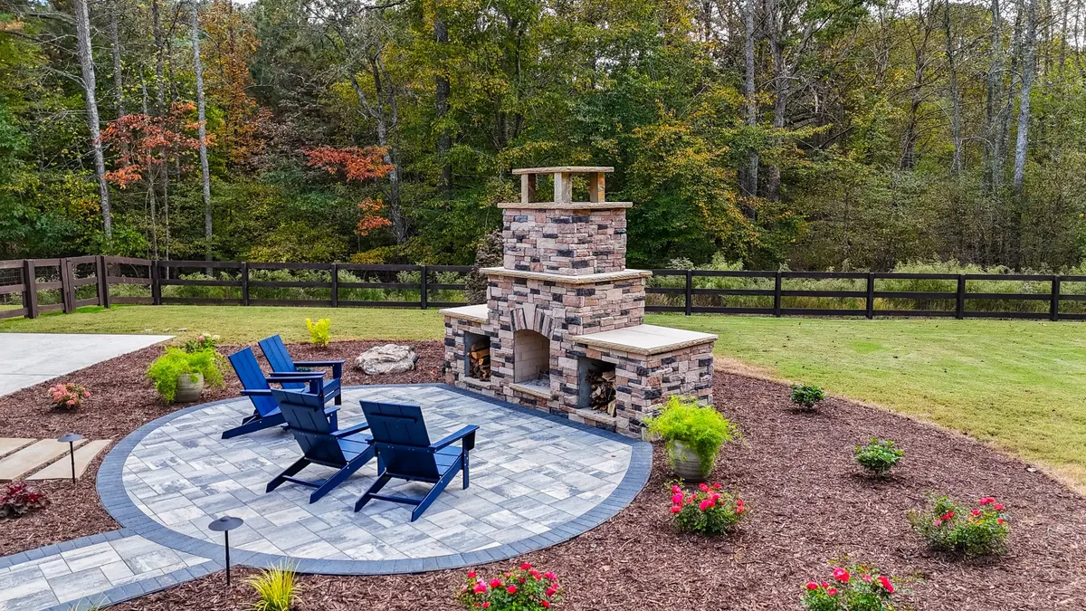 Golden-hour view of the Ball Ground stone fireplace and circular paver patio