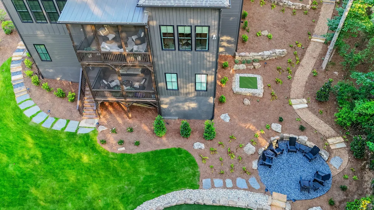 Overhead drone view of the Blueberry Ridge home and full-yard build: putting green, lawn, and seating terrace