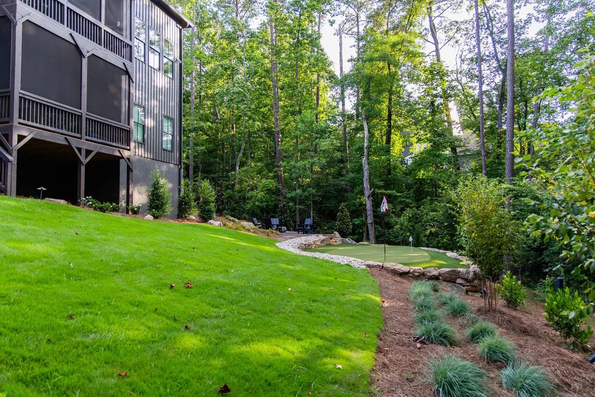 After: the new lawn stepping up past the boulder wall to the putting green