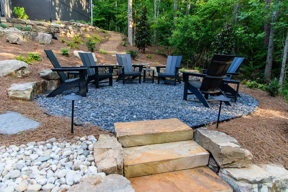 After: Adirondack chairs on the slate-gravel seating terrace beside the boulder wall