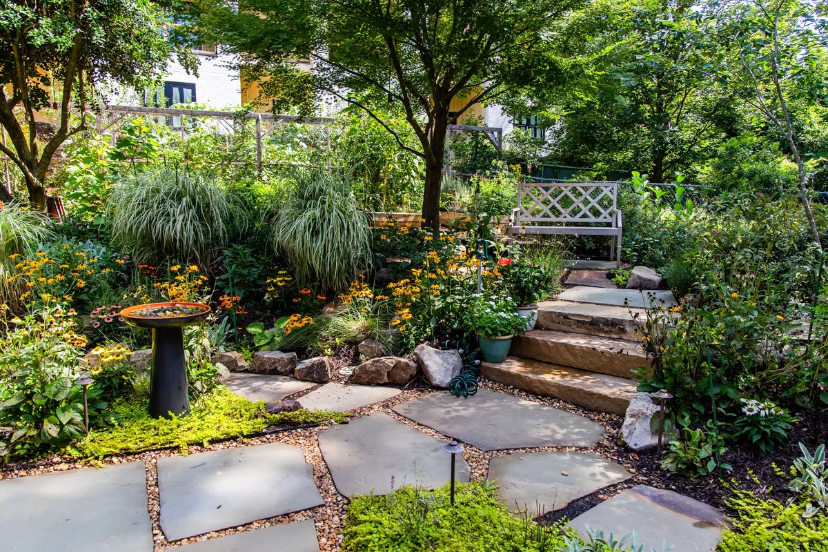 Garden bench and stone steps set into the pollinator garden