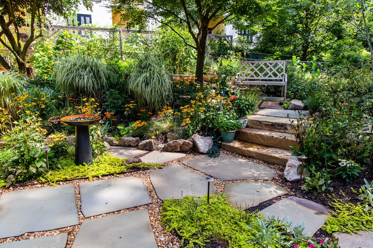 Stone slab steps and rock-edged planting beds in an established Atlanta garden by GreenTree Landscapes