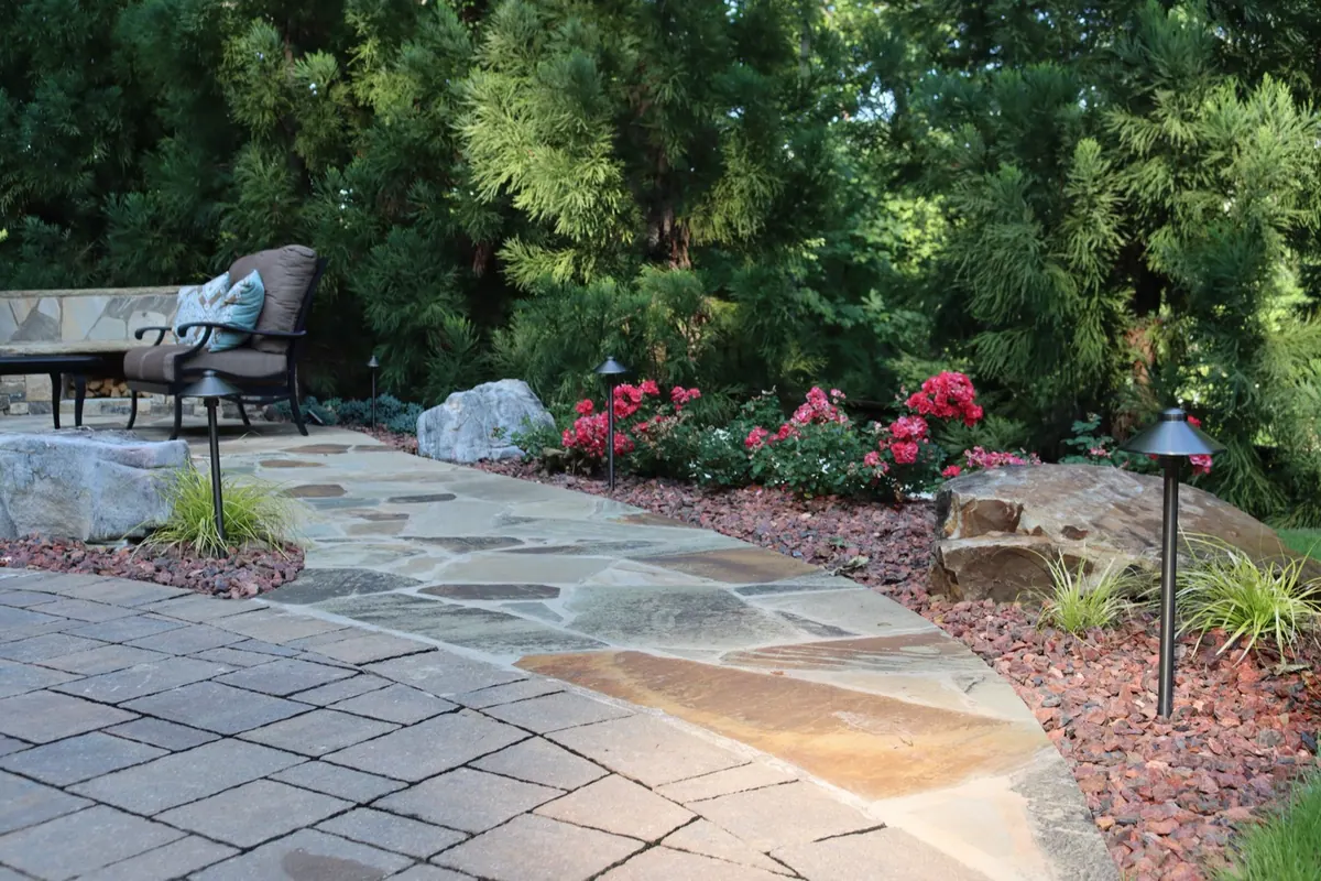 Paver patio and seating tucked into a wooded backyard