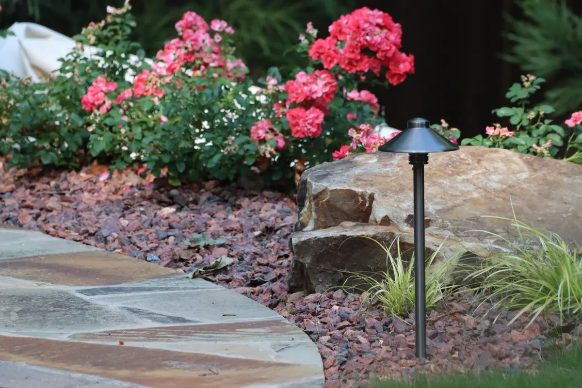 Roses, boulders, and path lighting along a flagstone walk