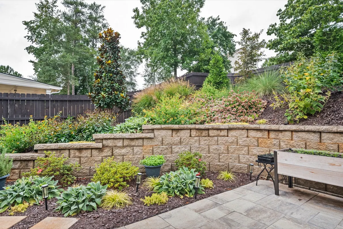 Terraced retaining wall with cedar planter boxes above a paver patio