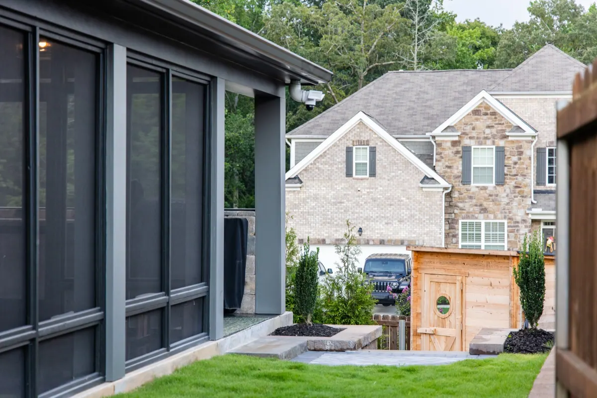 The screened porch and covered patio from the new lawn at the Fulton Estate