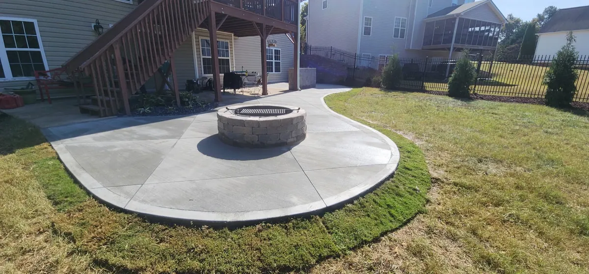 Circular concrete fire pit patio set into a new lawn