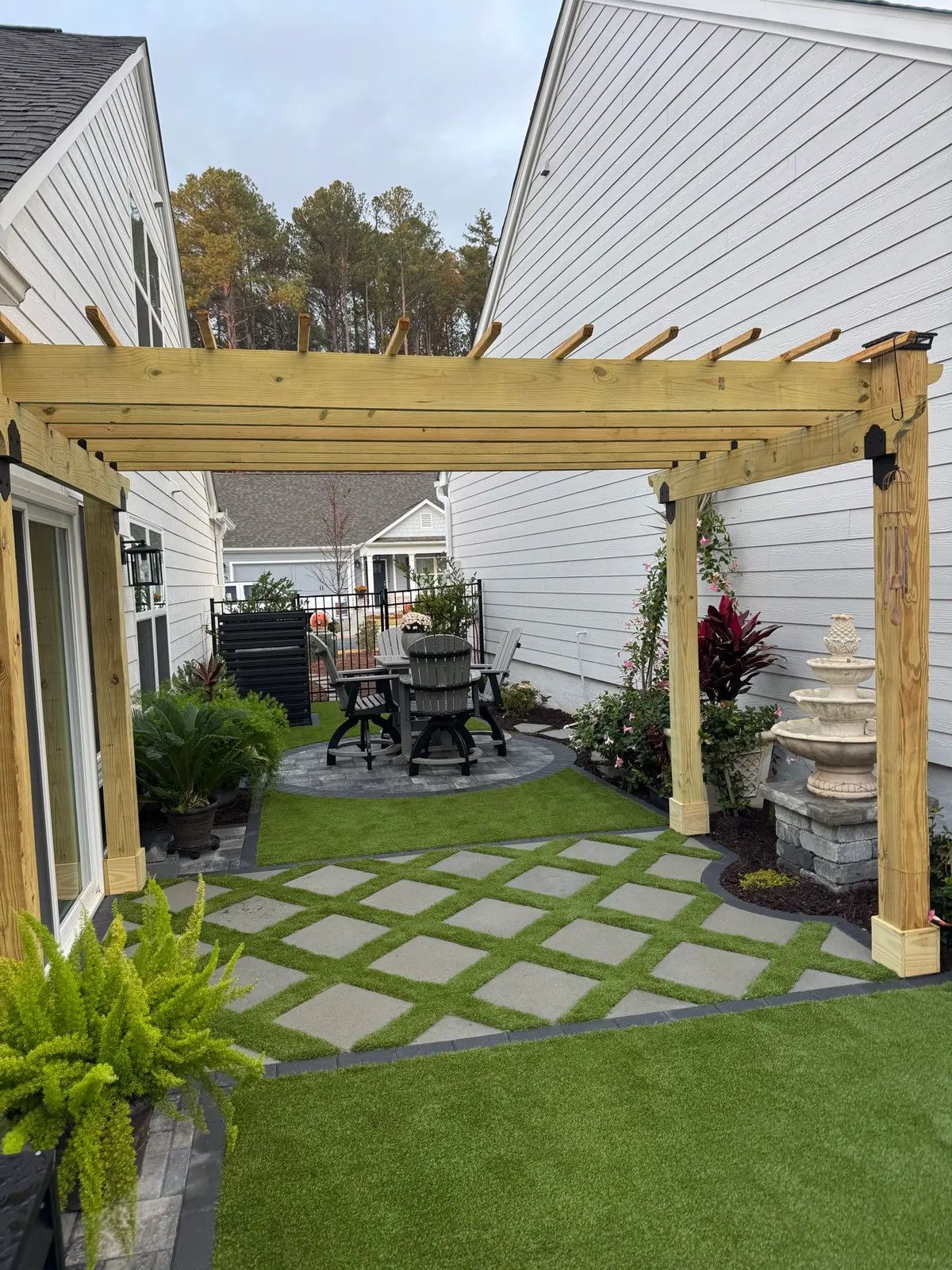Cedar pergola with espalier trellis wall beside a fresh lawn