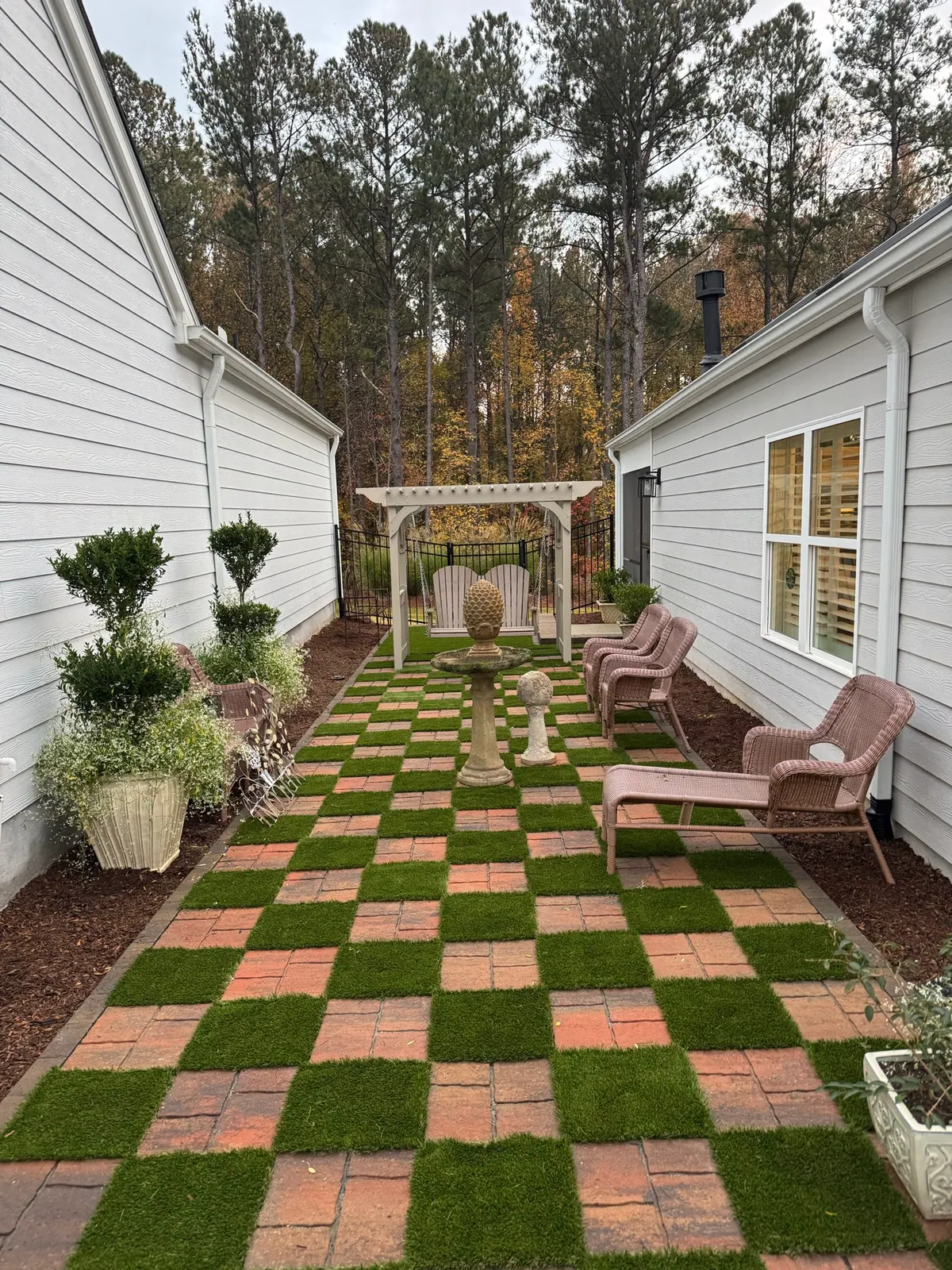 Checkerboard turf and paver courtyard with pergola